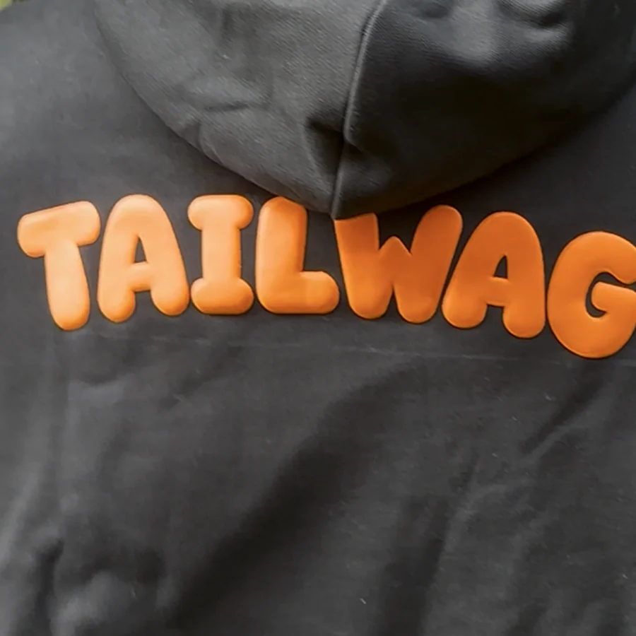 Close-up of the raised orange puff-print TAILWAG wordmark