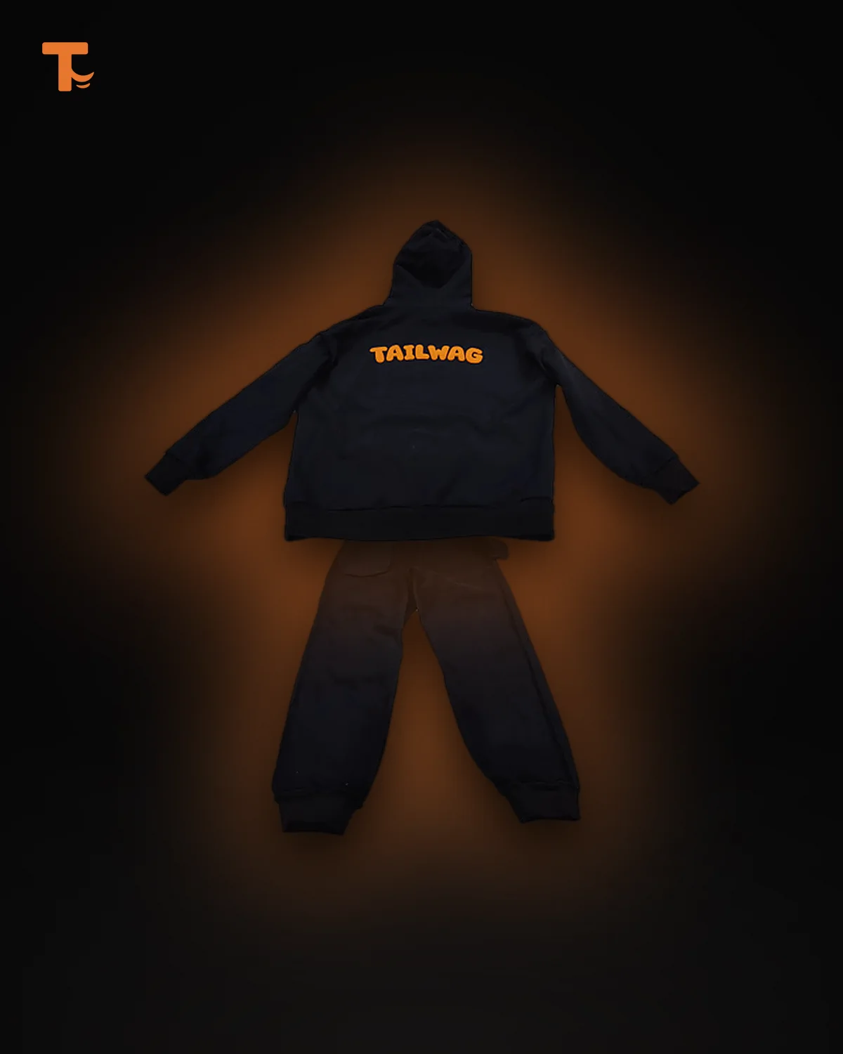 The Heavy Set: black hoodie with the orange TAILWAG puff print across the back, above matching black trackies